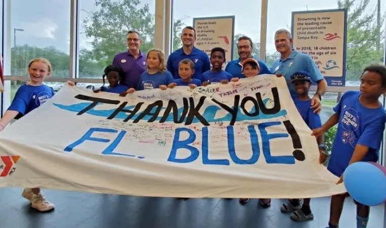 Young swimmers along with Y CEOs (L to R: YMCA of Greater St. Petersburg President/CEO David Jezek, Tampa Metropolitan Area YMCA President/CEO Matt Mitchell, Florida Blue’s Market President, West Florida Region David Pizzo, YMCA of the Suncoast President/CEO G. Scott Goyer) thank the Florida Blue Foundation for their generous donation to the Y’s Safety Around Water program.