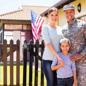 military dad posing with wife and daughter